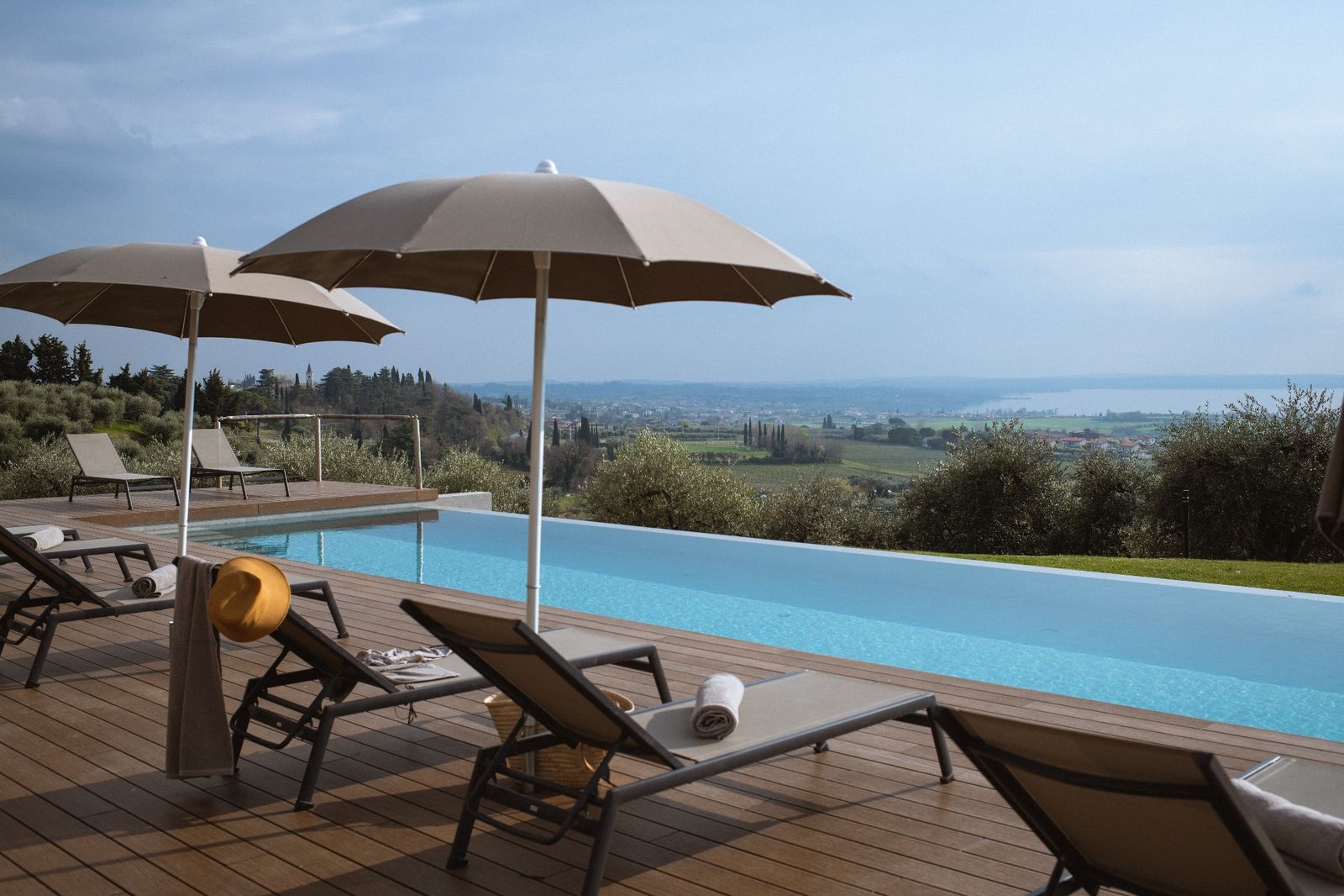 Pool und Sonnenschirm mit Blick über den Gardasee